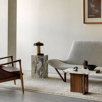 Modern living room set featuring a gray sofa, wood accents, and marble patterns on tables. Neutral tones and textures.
