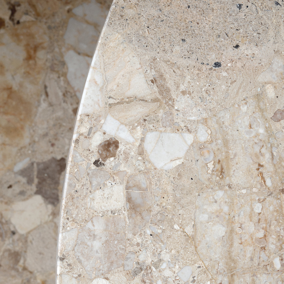 Beige marble surface with subtle white and gray veining, showcasing a natural stone pattern and texture.