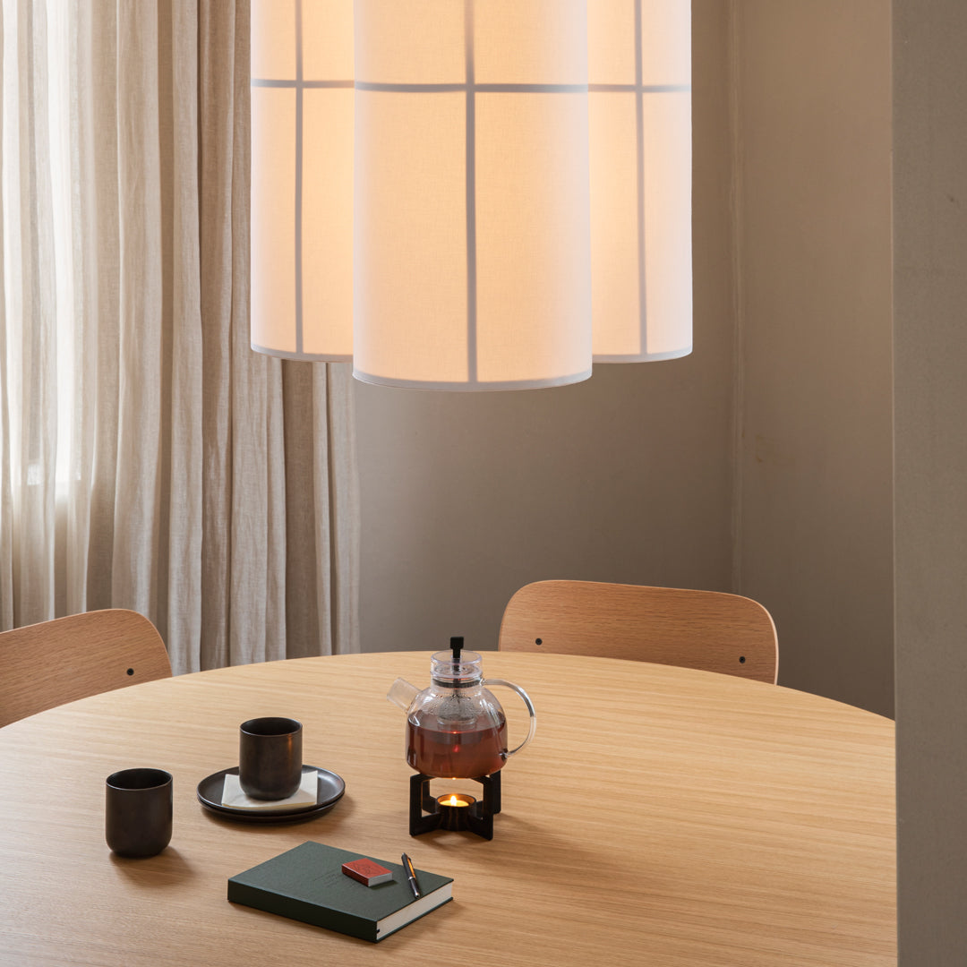 Minimalist dining scene featuring soft beige colors and natural wood patterns with an elegant pendant light.