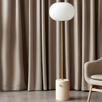 Modern floor lamp with white globe shade, gold detailing, and a textured cream base. Elegant neutral tones and minimal design.