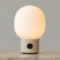 Soft white glow lamp with a smooth, rounded glass shade and a minimalistic gray base. Sleek and modern design.