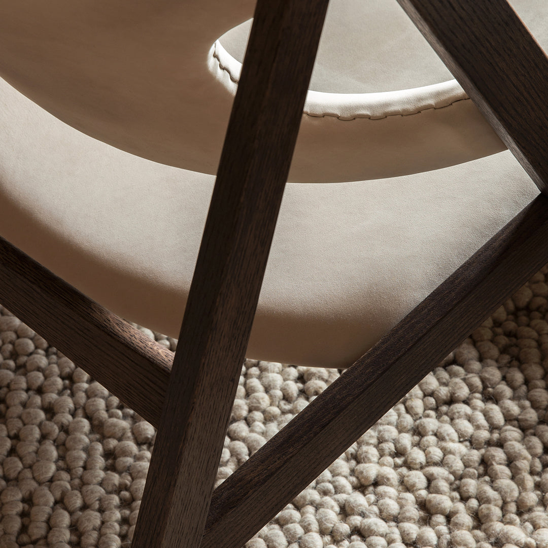 Beige and off-white textures with a dark wood frame, set against a creamy, woven rug. Modern and minimalist design.