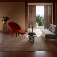 Modern seating in vibrant red and muted gray, complemented by natural textures and earthy tones of the surrounding space.