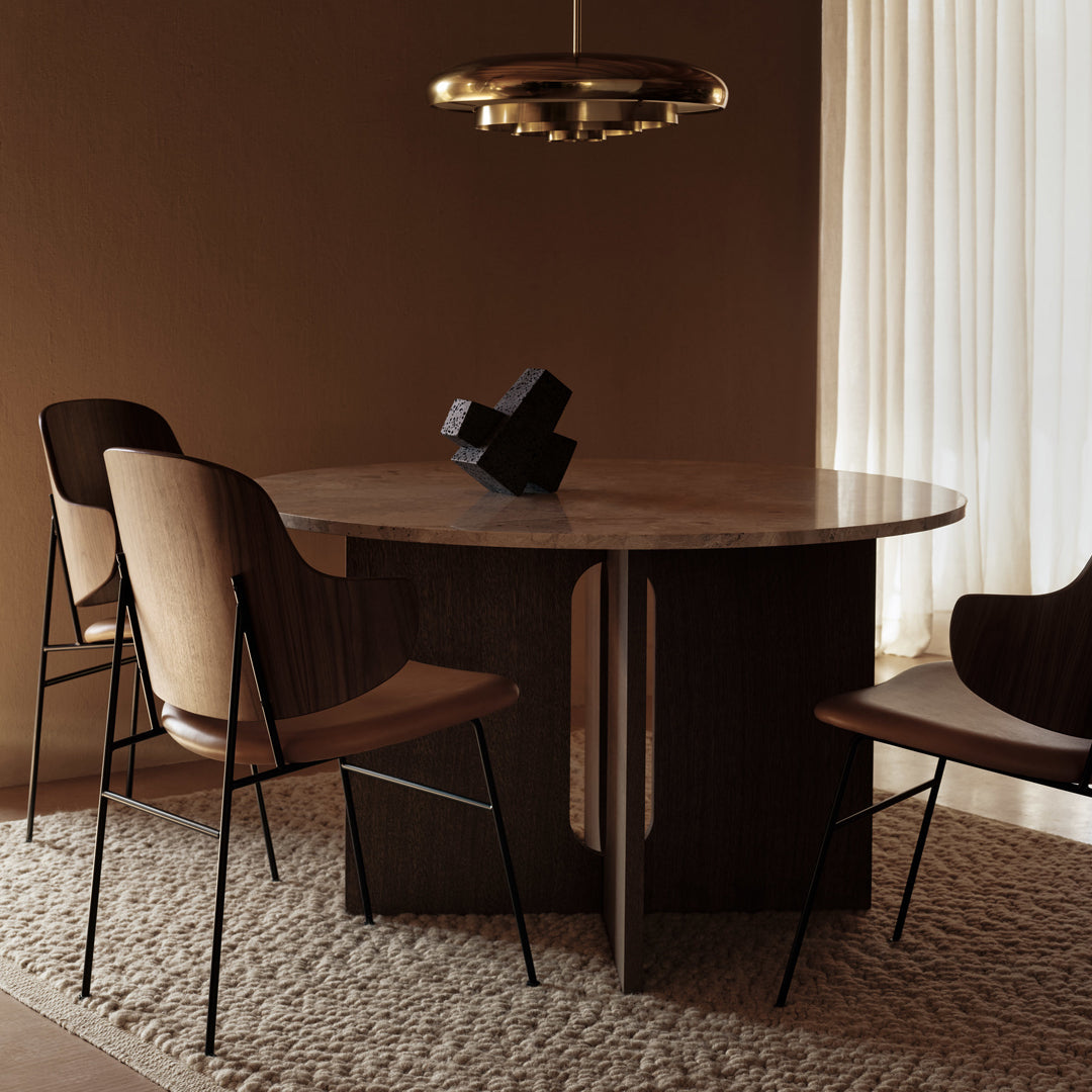 Round marble dining table with dark wood base, surrounded by beige and brown mid-century chairs on a textured rug.