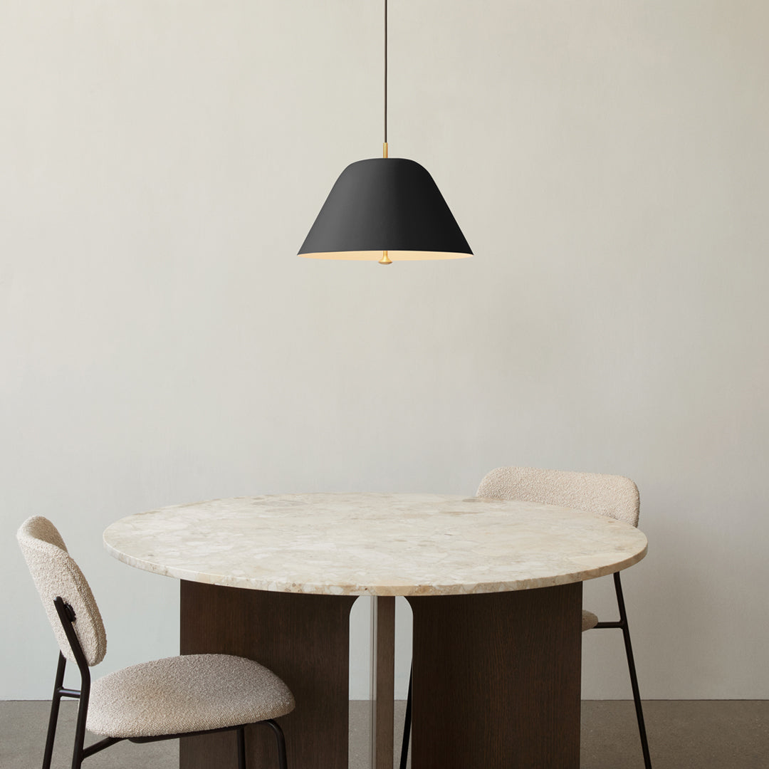 Black pendant lamp above a round marble table with neutral-toned chairs, creating a modern, minimalist look.
