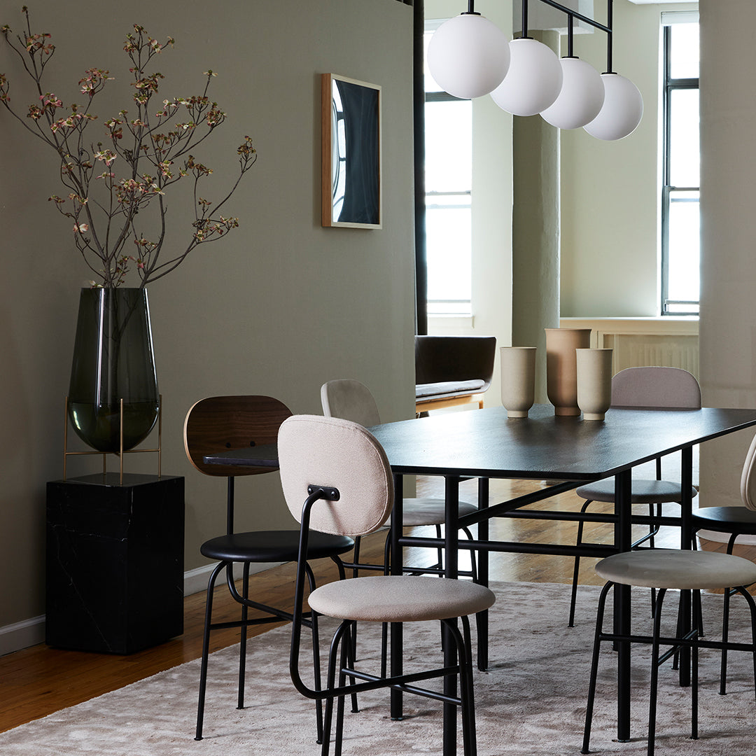 Modern dining room featuring neutral tones, elegant patterns, and soft textures in chair upholstery and decor.
