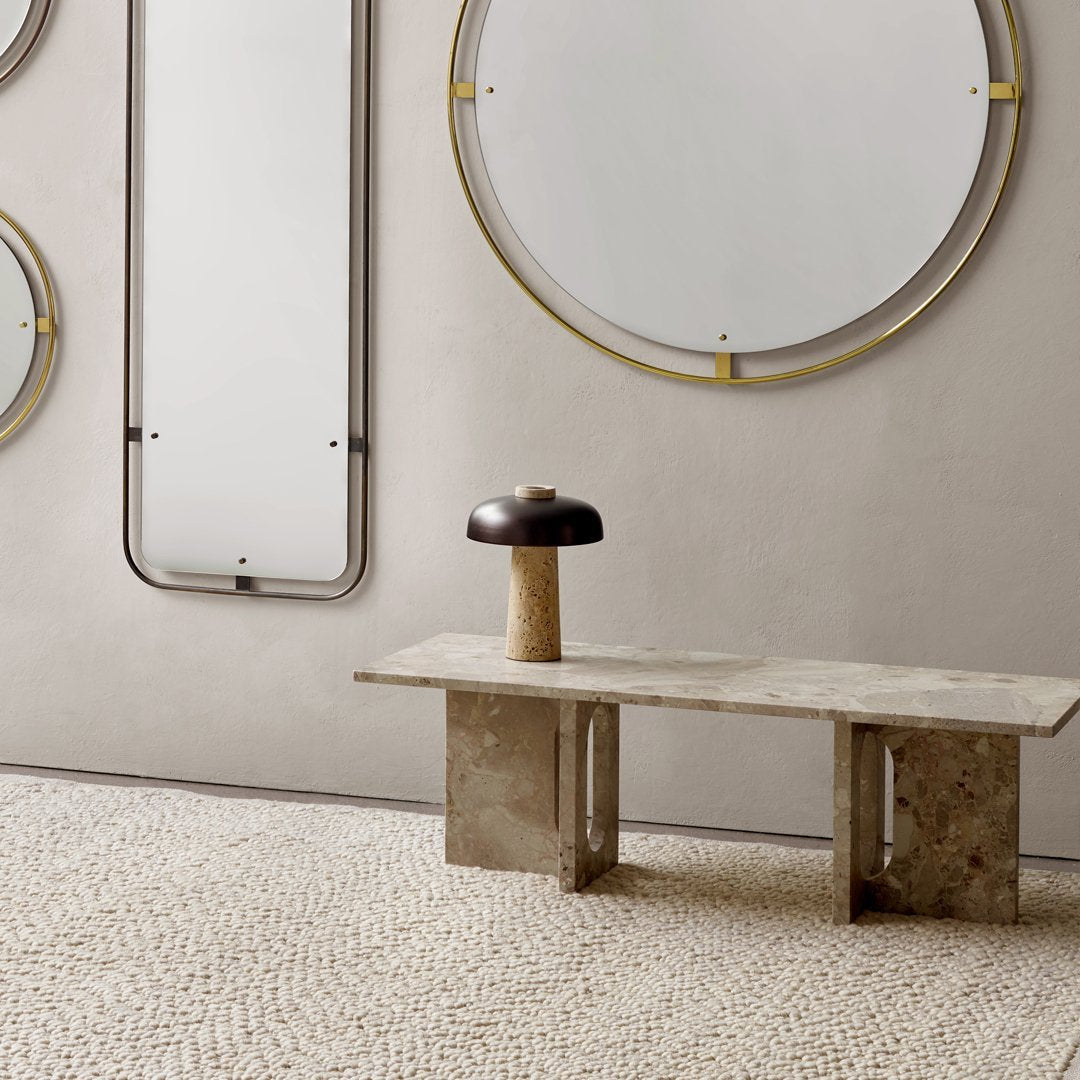 Modern circular mirrors with gold accents against a neutral wall, complemented by a textured beige rug.