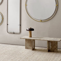 Modern circular mirrors with gold accents against a neutral wall, complemented by a textured beige rug.