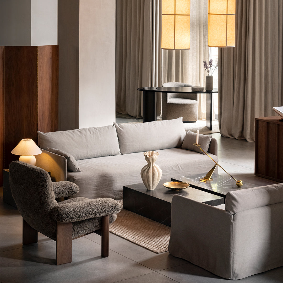 "Soft beige sofa and chair with textured brown fabric, complemented by warm gold accents and neutral-toned decor."