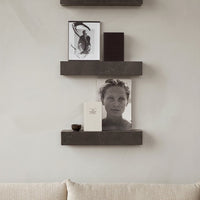 "Stylish shelves featuring dark wood, gray accents, and black-and-white photo prints against a soft beige background."