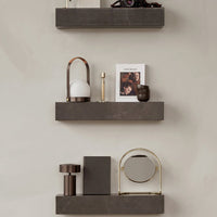 Dark gray marble shelves with gold accents and minimalist decor items in neutral tones. Elegant and modern design.
