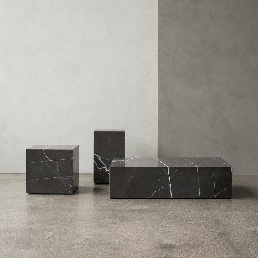 "Elegant black marble coffee table set with striking white veining on a minimalist concrete background."