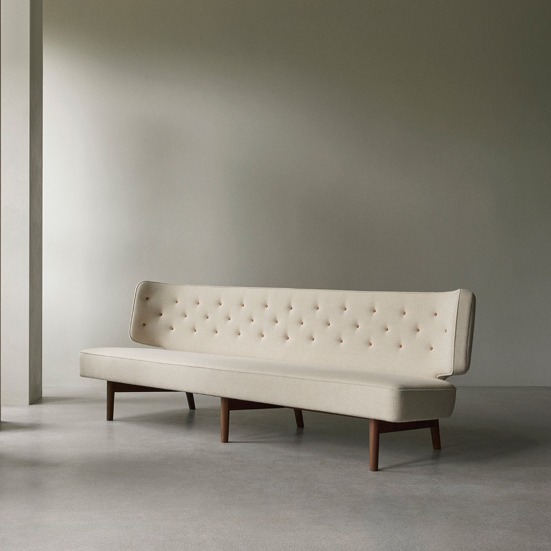 Beige upholstered sofa with tufted detailing and wooden legs, featuring a minimalist design. Perfect for modern decor.