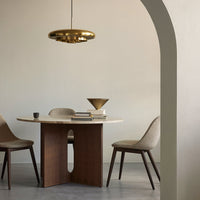 Modern dining room featuring a round marble table, beige chairs, and a gold pendant light against a neutral backdrop.