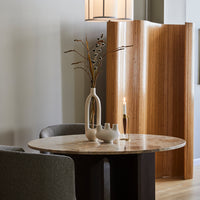 Round marble table with soft beige tones, complemented by dark wood, neutral vases, and natural accents.