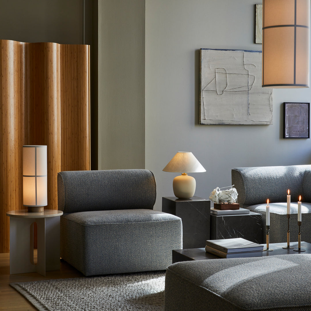 Stylish gray furniture set with textured patterns, complemented by warm wooden accents and soft lighting.