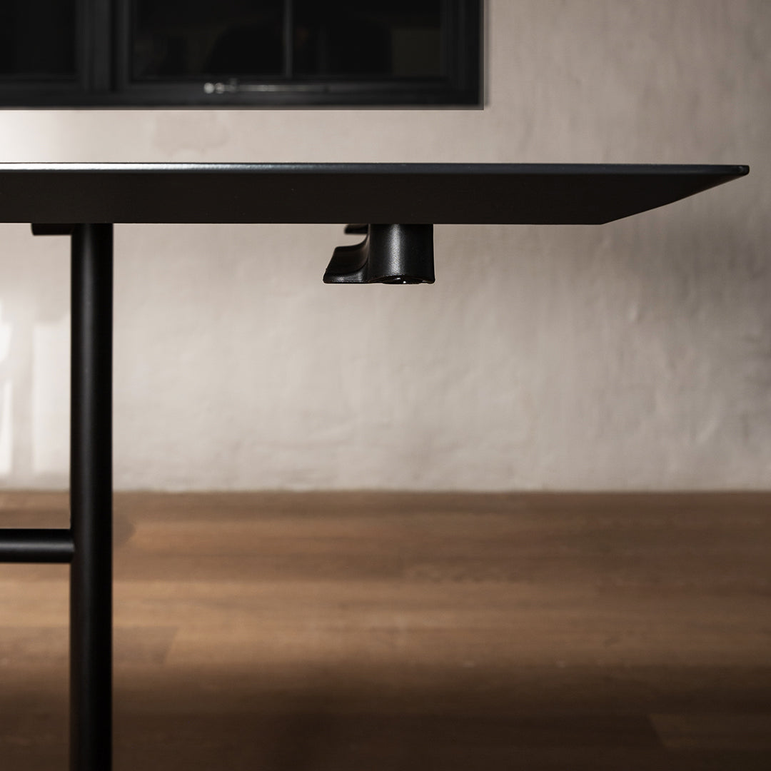 Sleek black table with a modern design, featuring a minimalist matte finish against a soft, neutral backdrop.