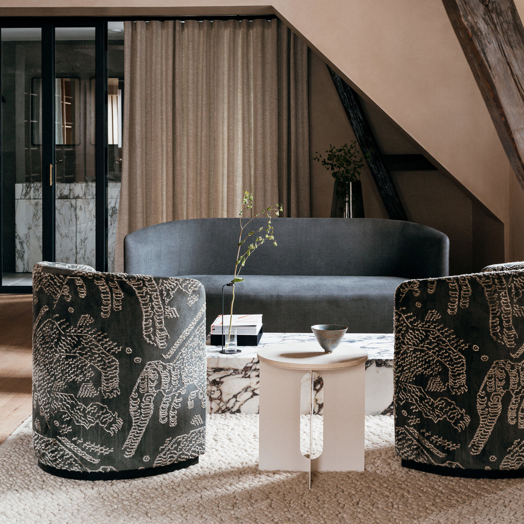 Patterned black and white accent chairs with a textured surface, featuring a modern, elegant design in a neutral-toned living room.
