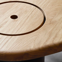 Natural light oak wood surface featuring a circular pattern and smooth texture.