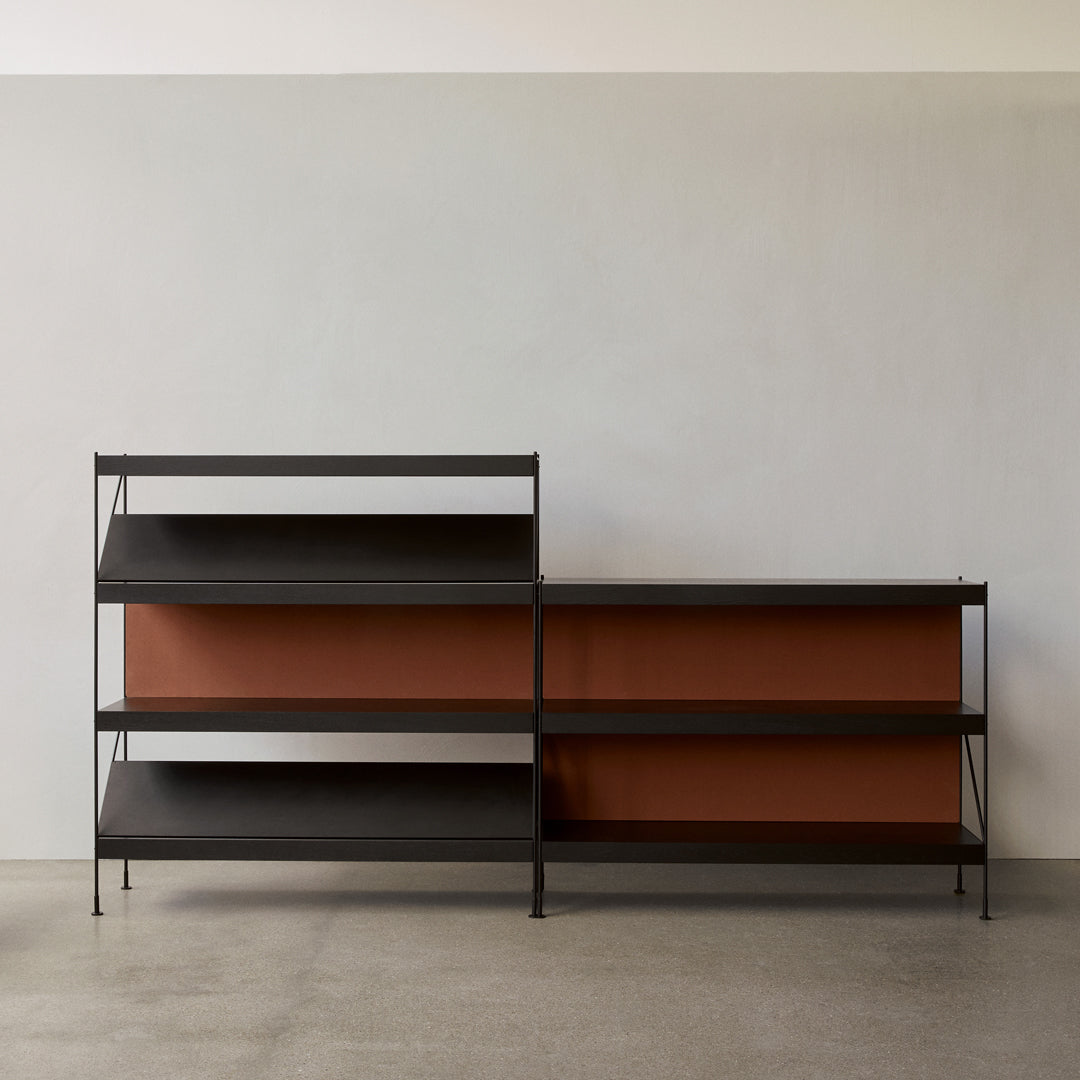 Black metal shelving unit with rich rust-colored back panels, set against a neutral backdrop. Modern minimalist design.