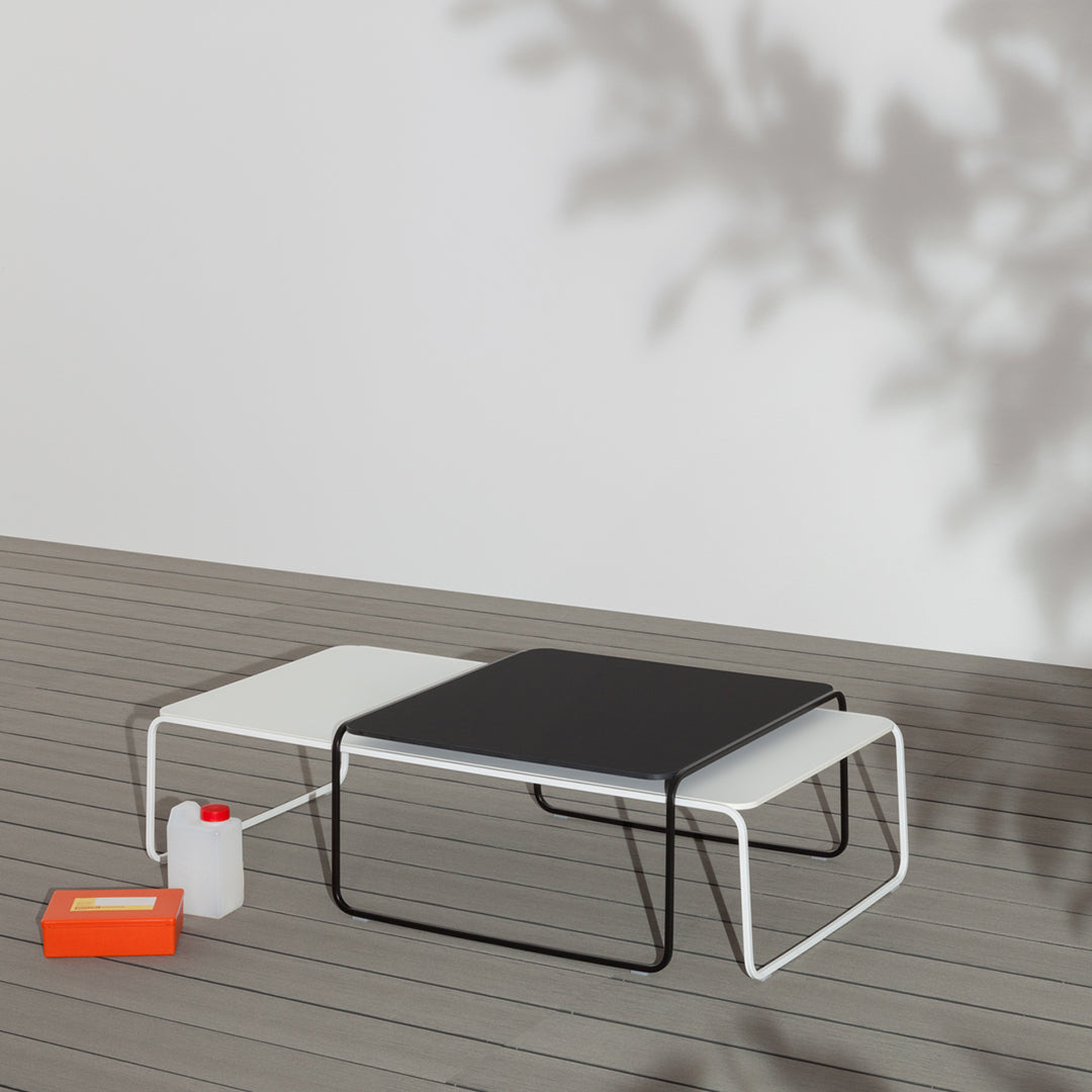 Modern coffee table in black and white with sleek lines, complemented by bold orange accents and a minimalist design.