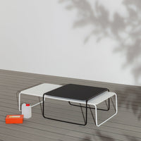 Modern coffee table in black and white with sleek lines, complemented by bold orange accents and a minimalist design.
