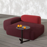 Burgundy and deep red sectional sofa with smooth, modern lines and a minimalist black side table.