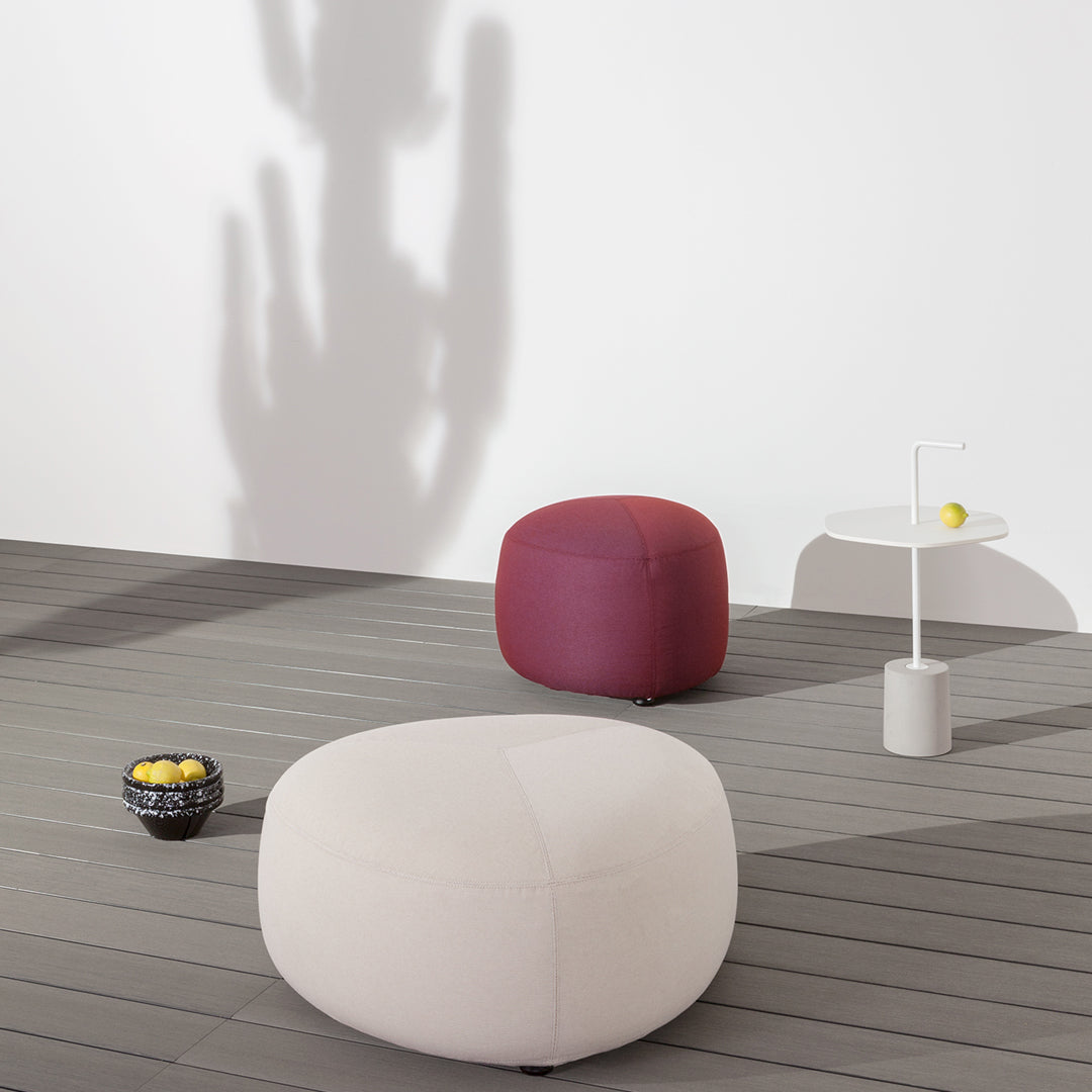 Minimalist poufs in cream and burgundy, featuring soft textures against a neutral backdrop.