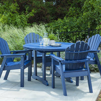 Adirondack dining set in deep navy blue, featuring smooth slats and a round table, surrounded by greenery.