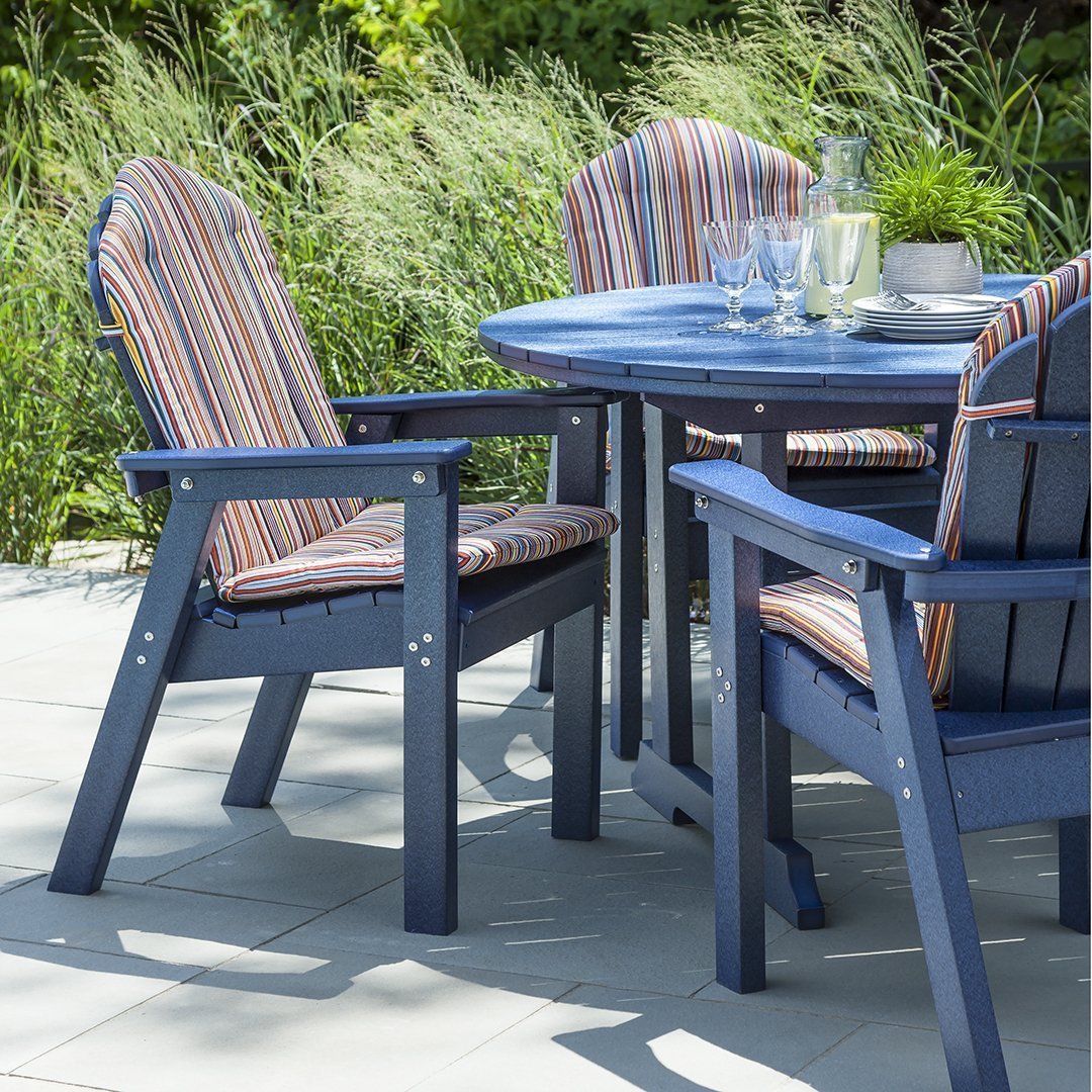 Blue outdoor dining set with striped cushions in vibrant colors, set against lush greenery. Perfect for patio decor.