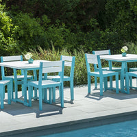 Lively turquoise outdoor dining set with white tabletops, set against lush greenery and a tranquil pool background.