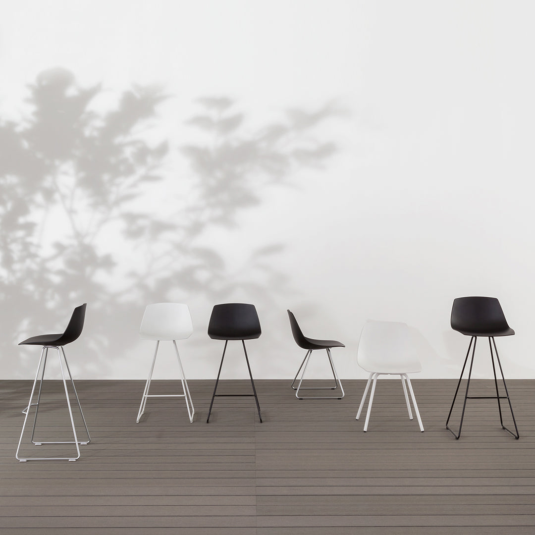 Set of modern chairs in black and white with sleek, minimalist design against a neutral background.
