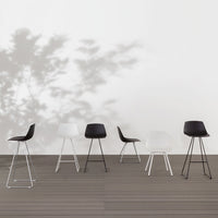 Set of modern stools in black and white, featuring sleek lines and minimalist design against a light backdrop.
