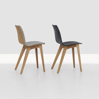 Natural wood and sleek black chairs with a smooth finish, showcasing modern design and minimalist style.