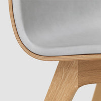 Light gray upholstery with smooth curves, contrasted by a natural wood finish for a modern look.