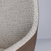 Textured gray fabric with subtle black flecks, complemented by a smooth brown leather trim. Stylish and modern design.