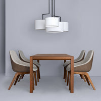 Modern dining set featuring a wood table, beige and brown patterned chairs, and white pendant lights on a gray wall.