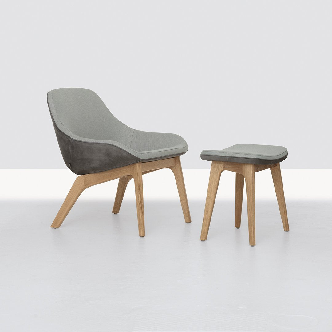 Gray cushioned stool with natural wood legs, featuring a modern minimalist design. Perfect for any decor style.
