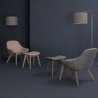 Modern light pink and gray chairs with natural wood legs against a dark gray backdrop, creating a stylish minimalist setting.