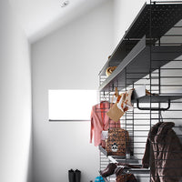 "Stylish black shelving with pink, brown, and patterned accessories displayed against a minimalist white wall."