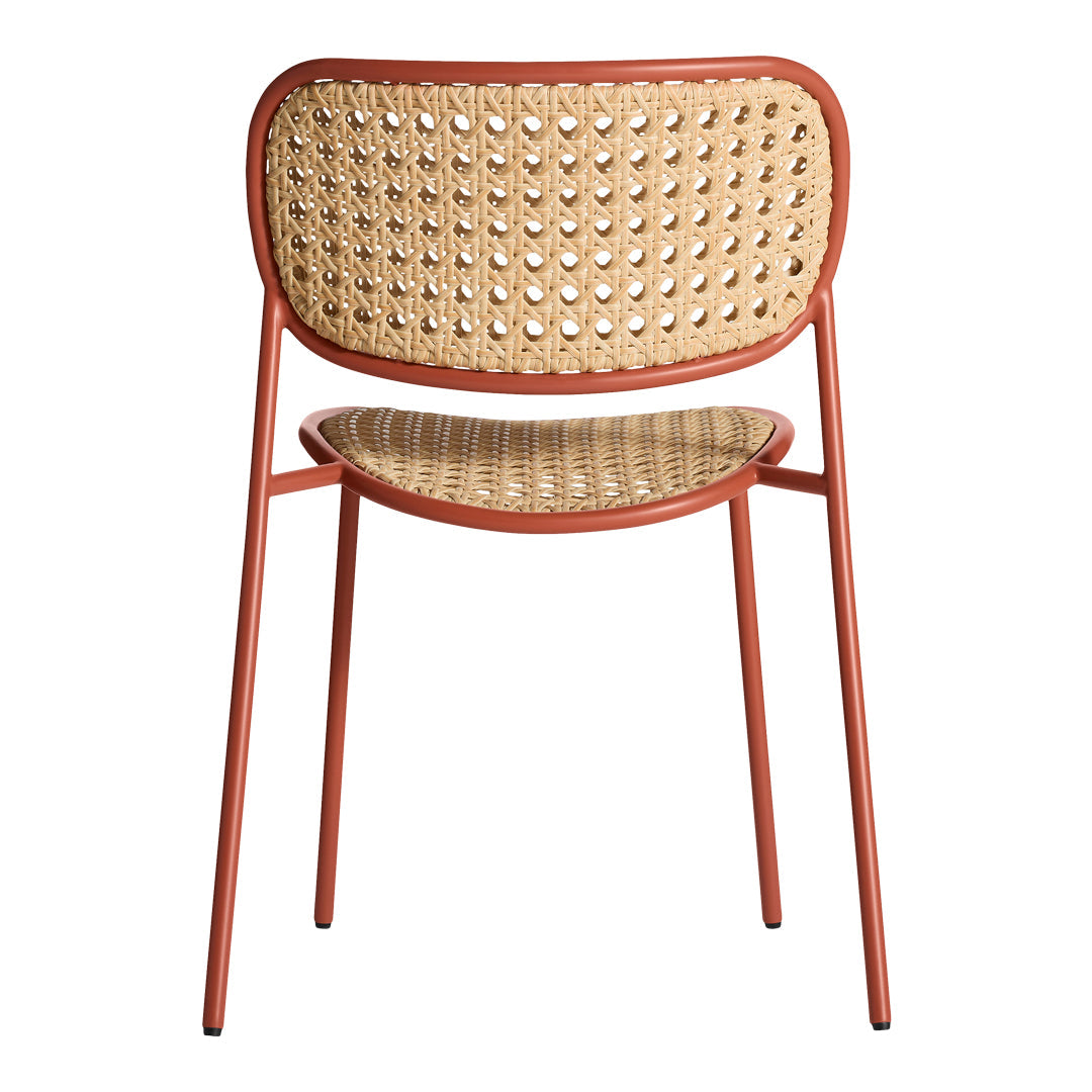 Rust-colored metal chair with woven cane back and seat, featuring a modern geometric pattern.