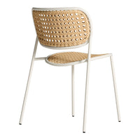 Woven rattan chair in natural tones with a white metal frame, showcasing a minimalist design and intricate pattern.