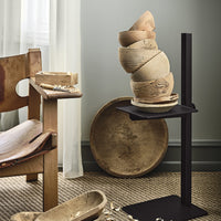 "Neutral earthy tones with rustic textures, featuring layered bowls and a sleek black stand."