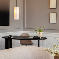 Modern home office featuring a soft gray palette, sleek black desk, and subtle beige accents. Elegant light fixtures enhance style.