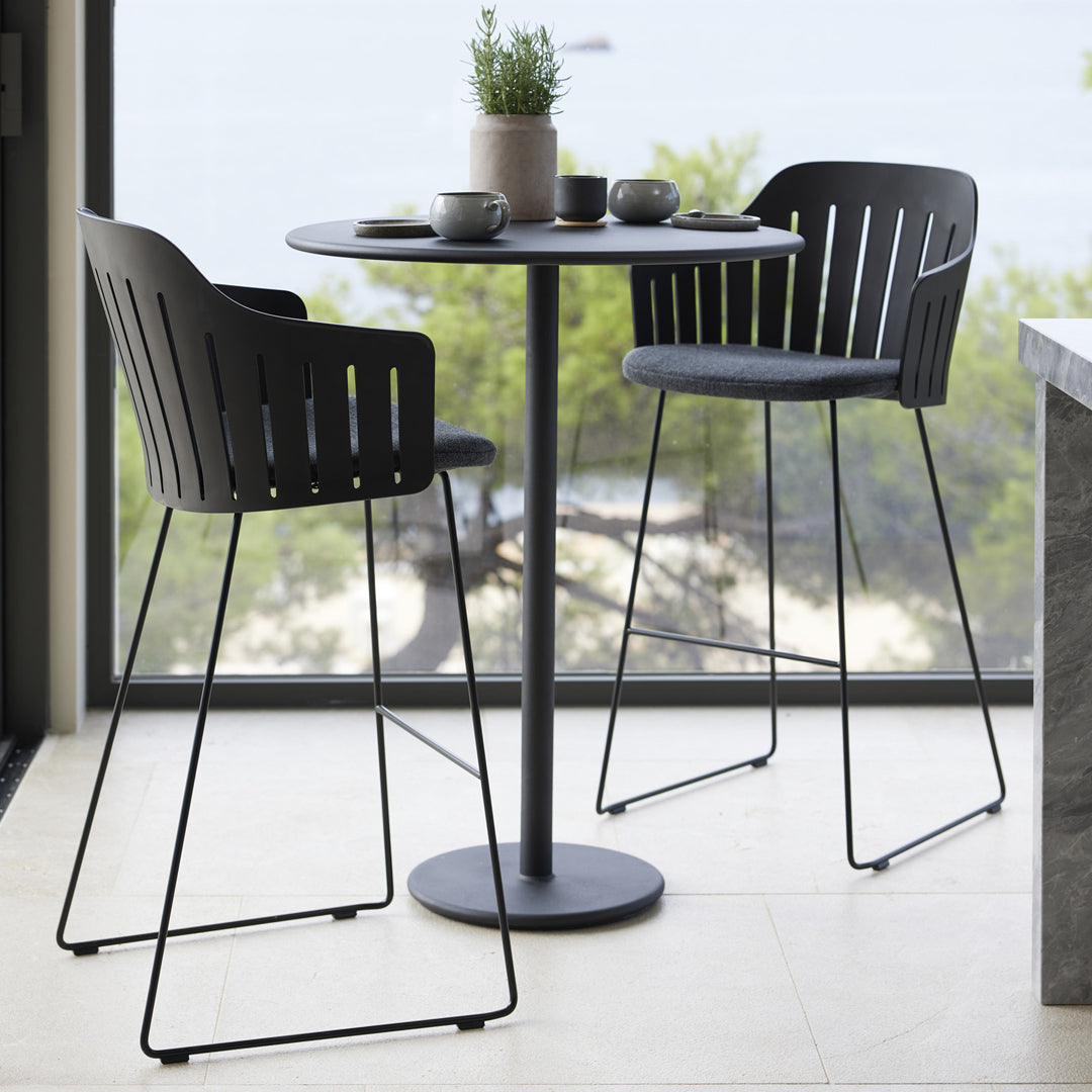 Modern black patio table and chairs with slotted pattern, perfect for stylish indoor or outdoor dining.