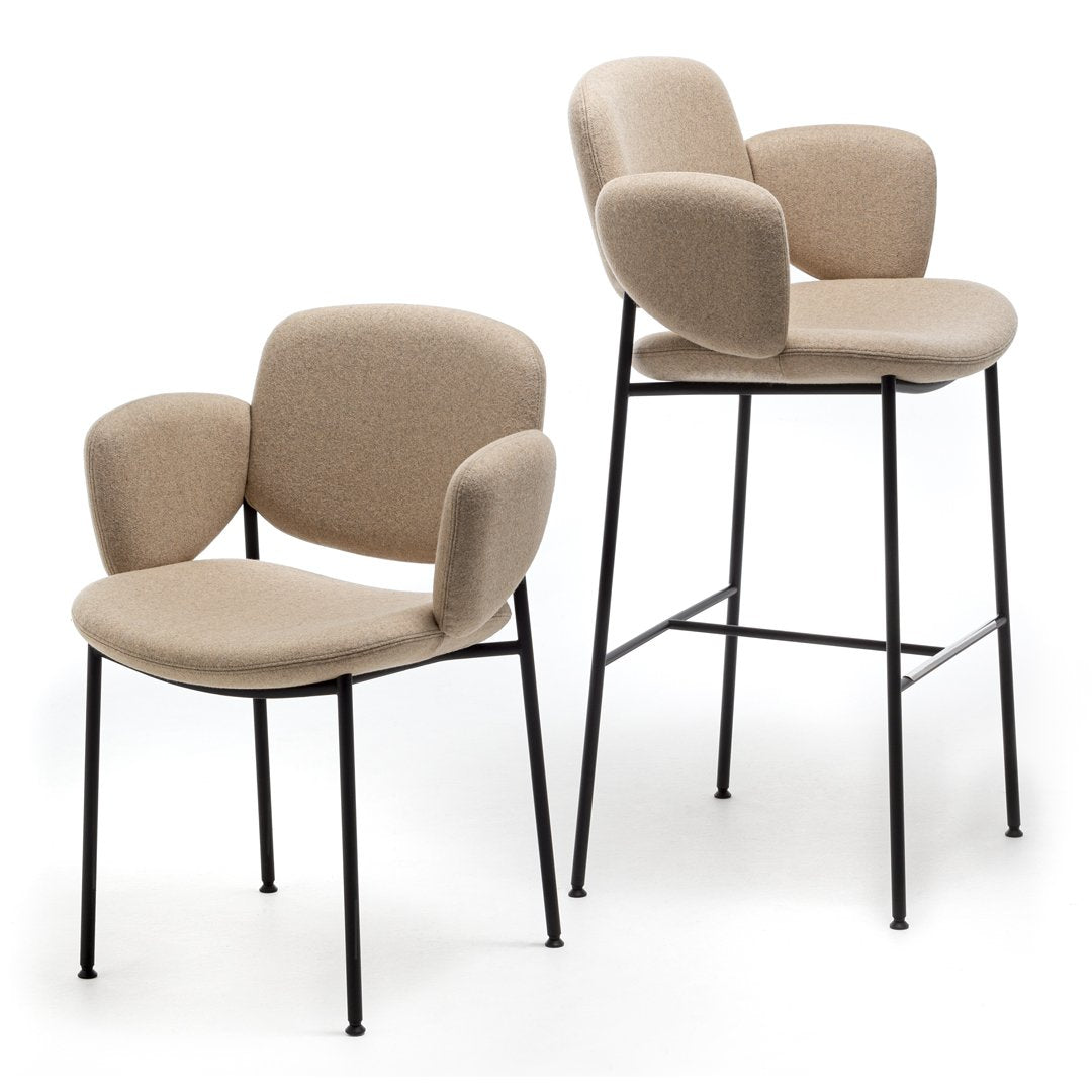 Beige upholstered chairs with curved arms and sleek black metal legs, showcasing a modern minimalistic design.
