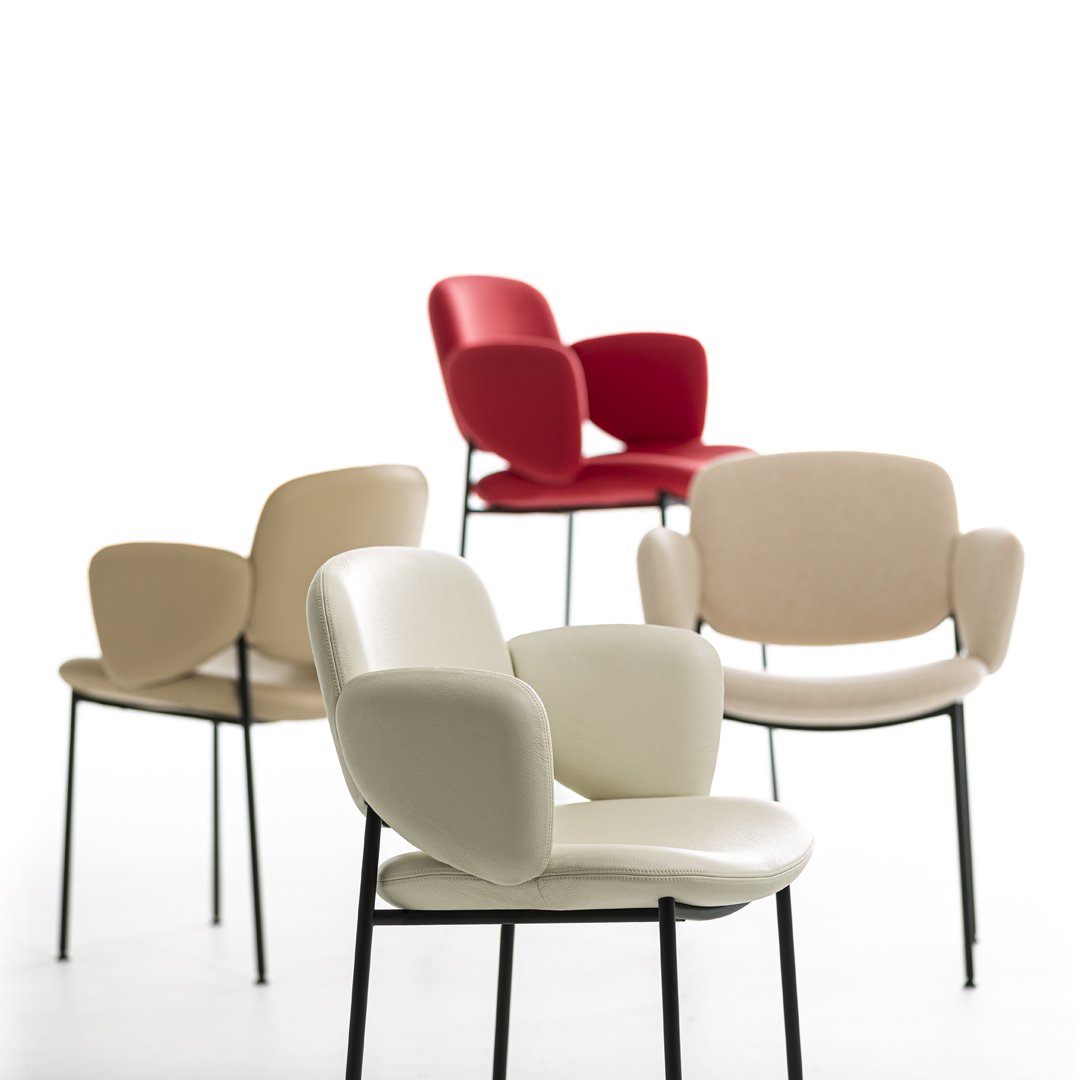 Colorful chair collection featuring red, beige, and white upholstery with sleek black metal legs and modern minimalist design.