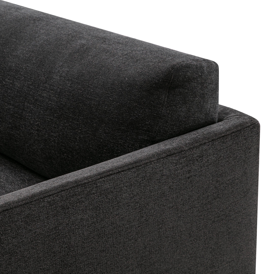 Dark gray textured fabric corner of a modern sofa showcasing a sleek geometric design.