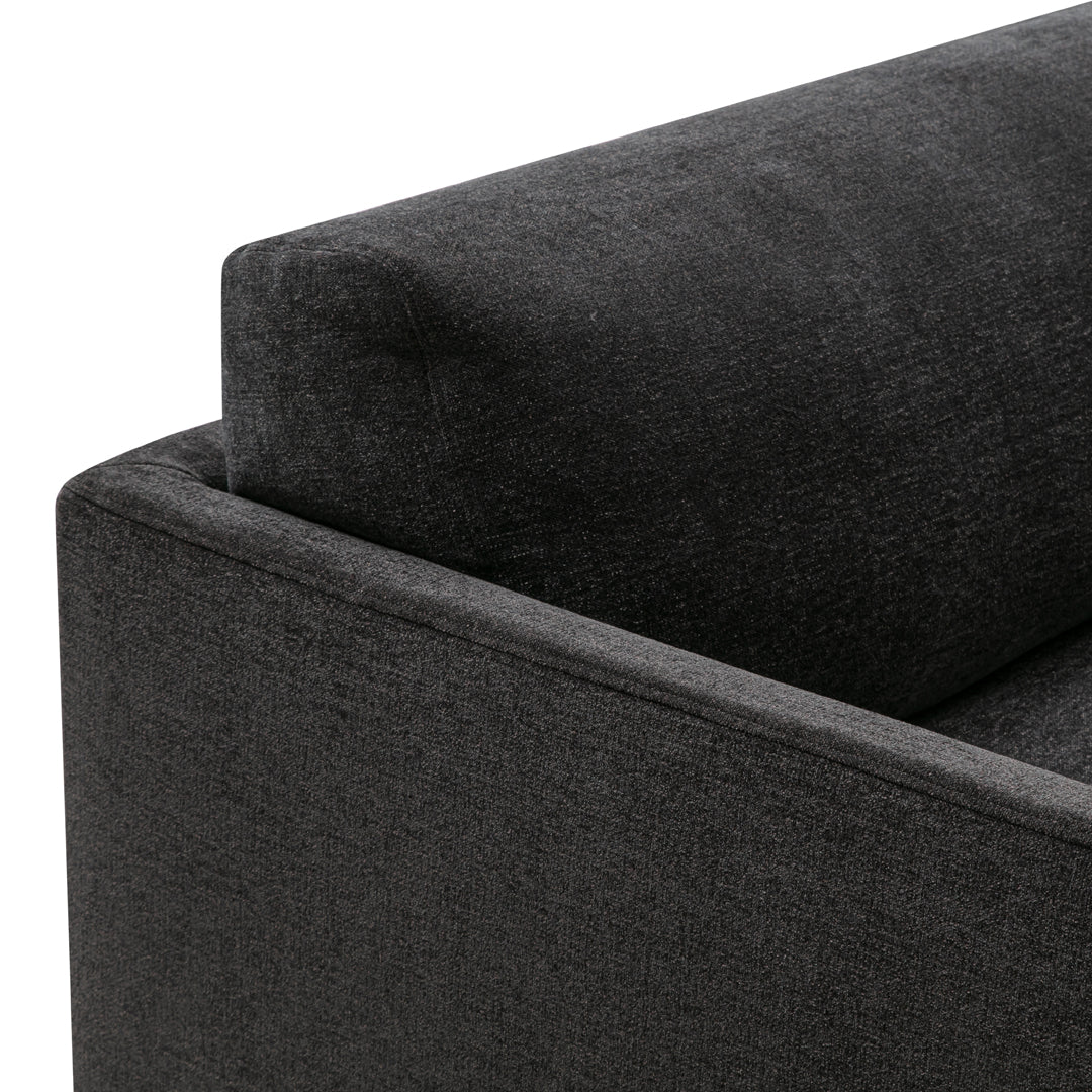 Dark gray textured fabric corner of a sofa, showcasing a modern and sleek design.