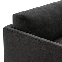 Dark gray textured fabric corner of a sofa, showcasing a modern and sleek design.